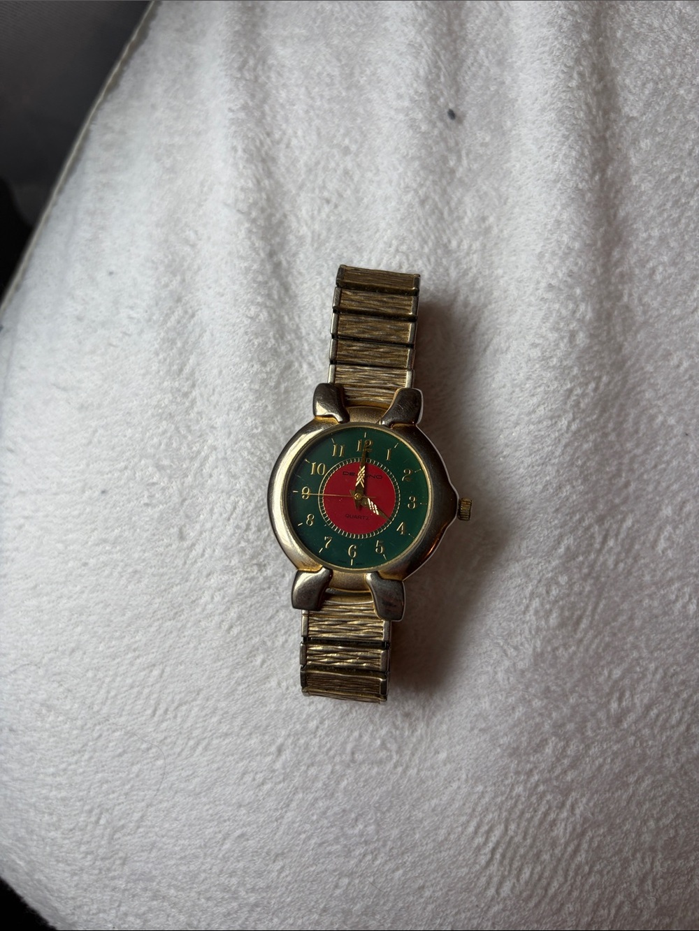 Dejuno gold watch with green and red colors